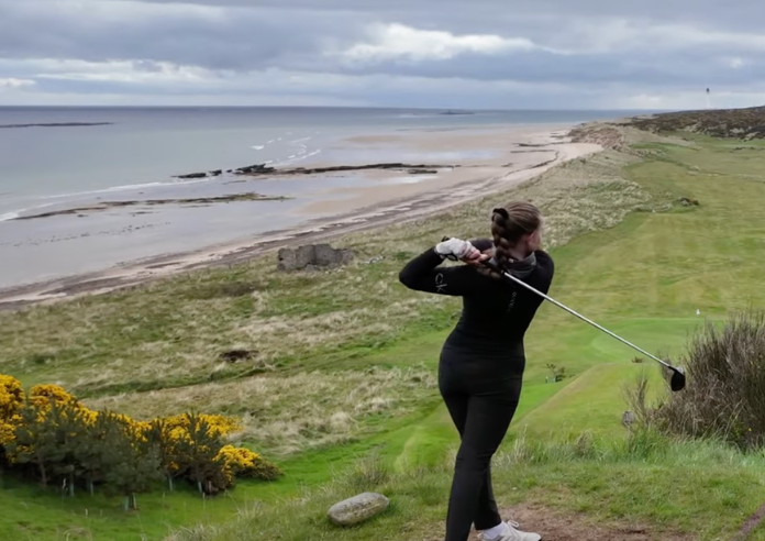 Female golfer at Covesea links with the beach in the background