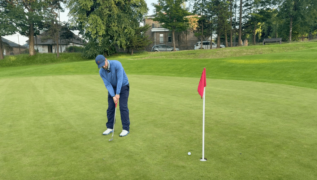 Cameron stands on the 18th green at Dalmuir hoping to hole his par putt.